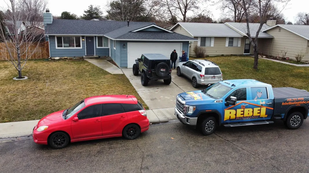 Rebel Roofing branded truck at a residential roofing project